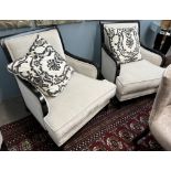 A pair of modern upholstered arm chairs with ebonised frames on square tapering legs