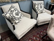 A pair of modern upholstered arm chairs with ebonised frames on square tapering legs