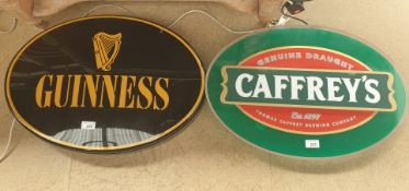 An electrified Caffrey's sign together with a similar Guinness sign