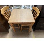 A modern kitchen table together with a pair of kitchen chairs