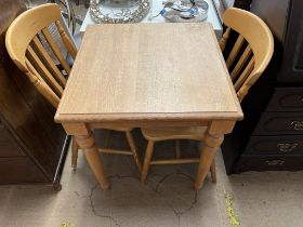 A modern kitchen table together with a pair of kitchen chairs
