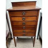 An Edwardian inlaid mahogany music cabinet with a raised back and six drawers with drop fronts on