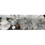 A large collection of crystal drinking glasses, decanters together with a punch bowl,
