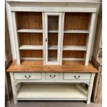 A modern painted pine kitchen dresser with a moulded cornice, shelves and central glazed door,