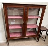 An Edwardian mahogany display cabinet with a pair of glazed doors and glazed sides on cabriole legs