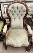 A Victorian walnut framed lady's chair with a carved back rail,