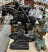 A large bronze model of a girl on a horse jumping a cross country fence together with another of a