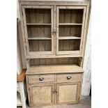 A Victorian pine dresser, the top with two doors and shelves,
