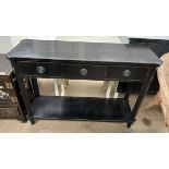 An ebonised pier table with a shaped rectangular top above three drawers on square legs united by