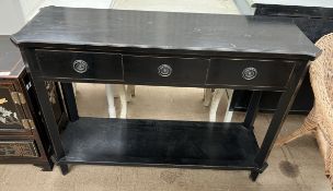 An ebonised pier table with a shaped rectangular top above three drawers on square legs united by