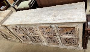 A limed sideboard with a rectangular top above four drawers with pierced metal panels on a shaped