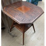 An Edwardian occasional table with a leaf carved square top and canted corners on four splayed legs