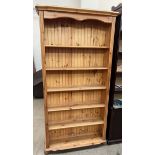 A pine bookcase with a moulded cornice and five shelves