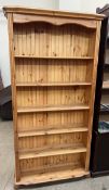 A pine bookcase with a moulded cornice and five shelves