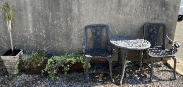 A garden table and two chairs together with three planters