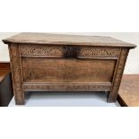 An 18th century oak coffer with a planked moulded top above a fan carved frieze and panelled body