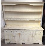 A cream painted pine dresser, with a moulded cornice above two shelves and spice drawers,