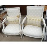 A pair of continental cream painted upholstered elbow chairs with pad upholstered back,