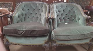A pair of Edwardian mahogany tub chairs with button back upholstery and pad seats on leaf carved
