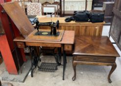 An oak cased singer sewing machine table with treadle base together with a mahogany coffee table of