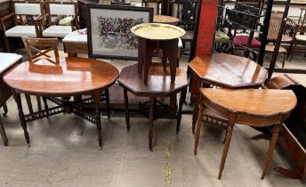A early 20th century mahogany table of oval form on turned legs and spindle cross frame on casters