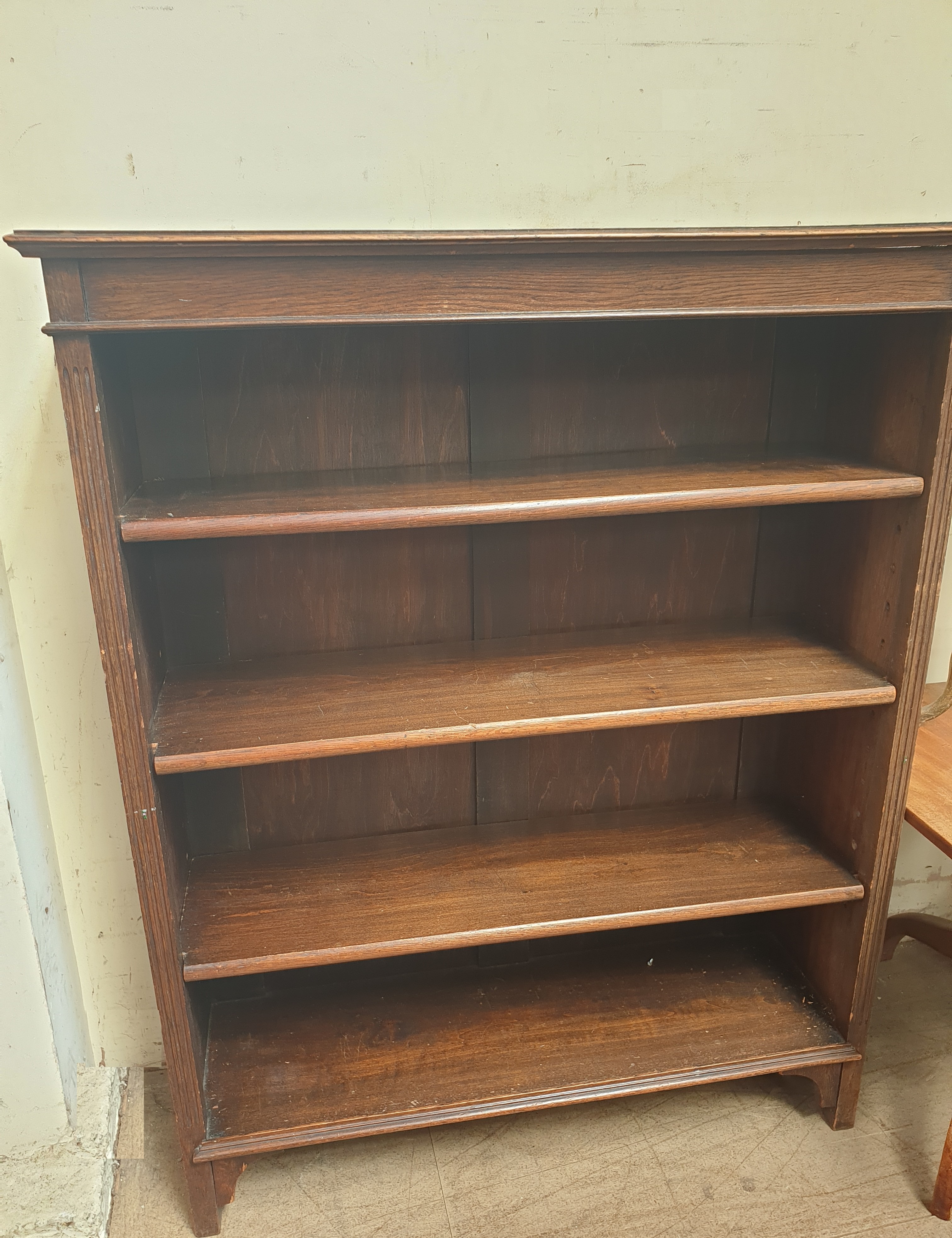 A 20th century oak bookcase with a moulded cornice above four shelves and square legs