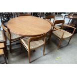 A mid 20th century teak extending dining table with two additional leaves together with a set of