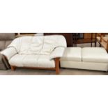 A cream leather three seater settee together with a cream leather ottoman