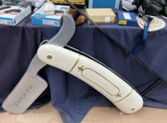 A large Barber shop hanging sign in the form of a cut throat razor