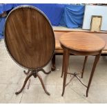 An Edwardian mahogany occasional table of circular form on square tapering legs united by an X