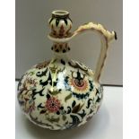 A Zsolnay Pecs Persian style jug decorated with flowers and leaves to a cream ground