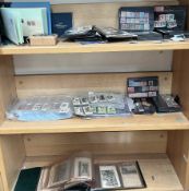 A collection of world stamps in display cards together with cigarette cards,