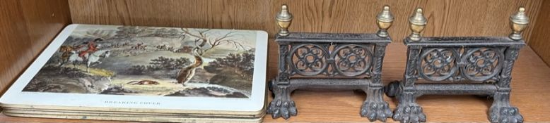 A pair of cast iron and brass fire tool rests with pierced body and lions paw feet and table mats