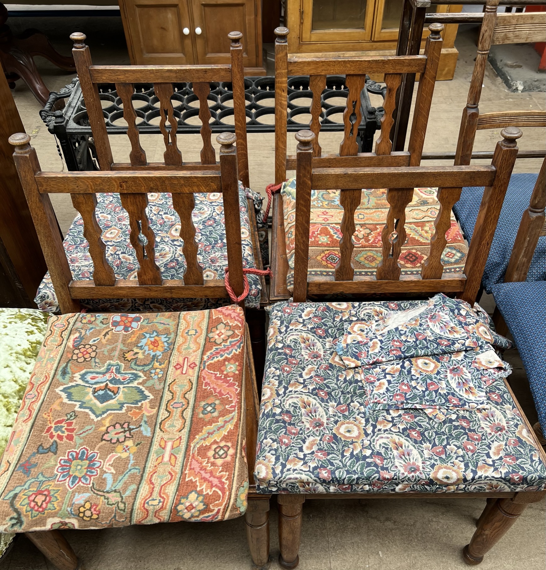 A set of four oak dining chairs with spindle backs together with seven other assorted chairs