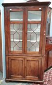 A 19th century mahogany standing corner cupboard with an astragal glazed top and cupboard base