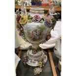 A continental porcelain vase with twin figural handles, flowerheads and leaves,