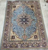 A large Persian rug with a blue ground and central radiating medallion,