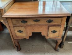 A mahogany lowboy with a rectangular top above an arrangement of three drawers on cabriole legs and