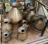 A set of seven French copper measuring jugs