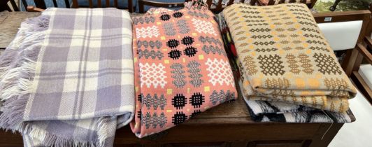 A Welsh blanket with a salmon pink ground together with another Welsh blanket and two other