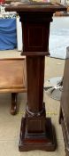 An Edwardian mahogany torchere with a crossbanded square top above a column on a stepped square