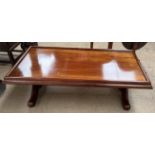 A mukwa wood coffee table of rectangular form on columns and splayed legs 150cm long