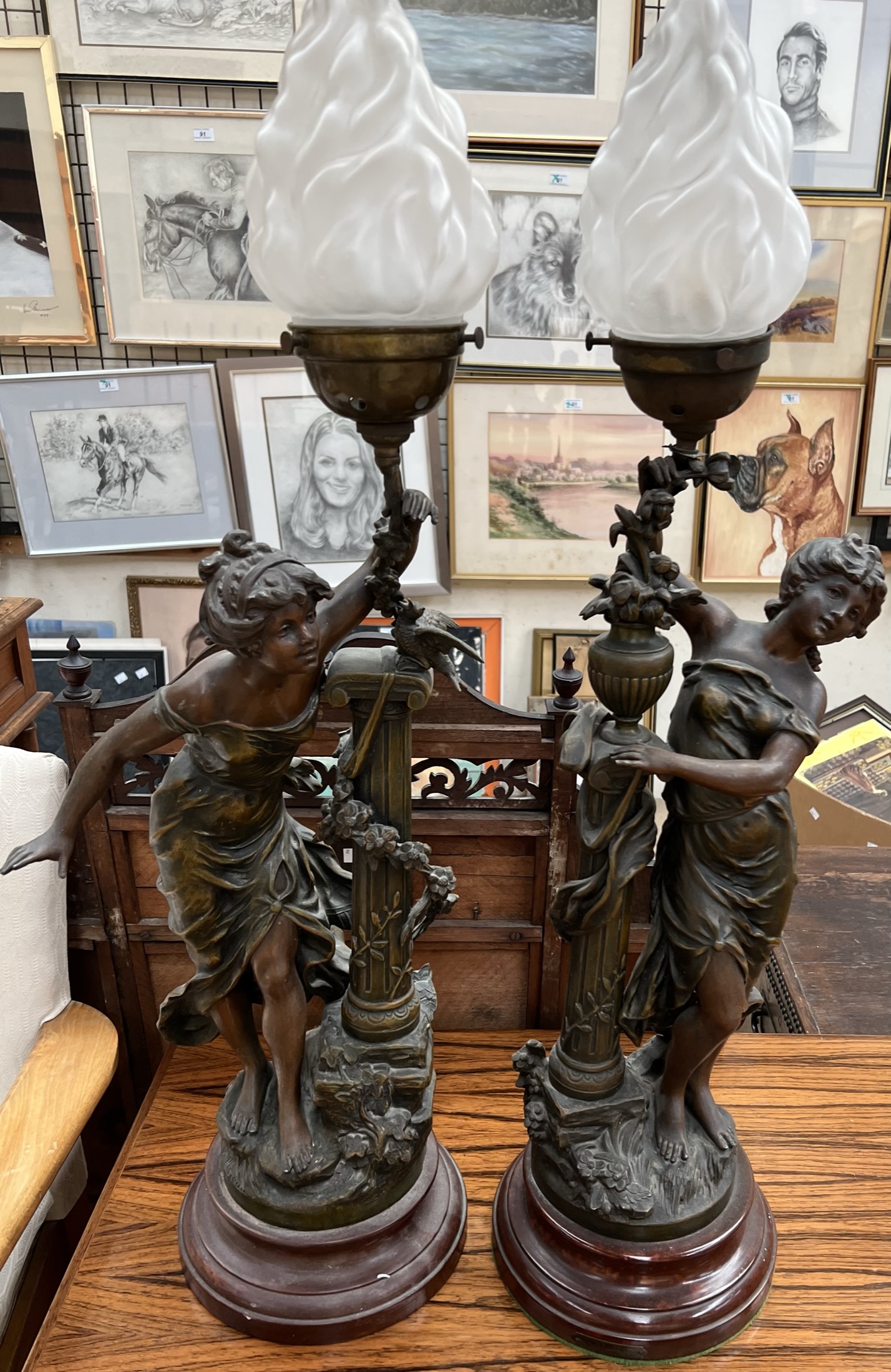 A pair of spelter table lamps in the form of maidens with festooned pillars on circular base