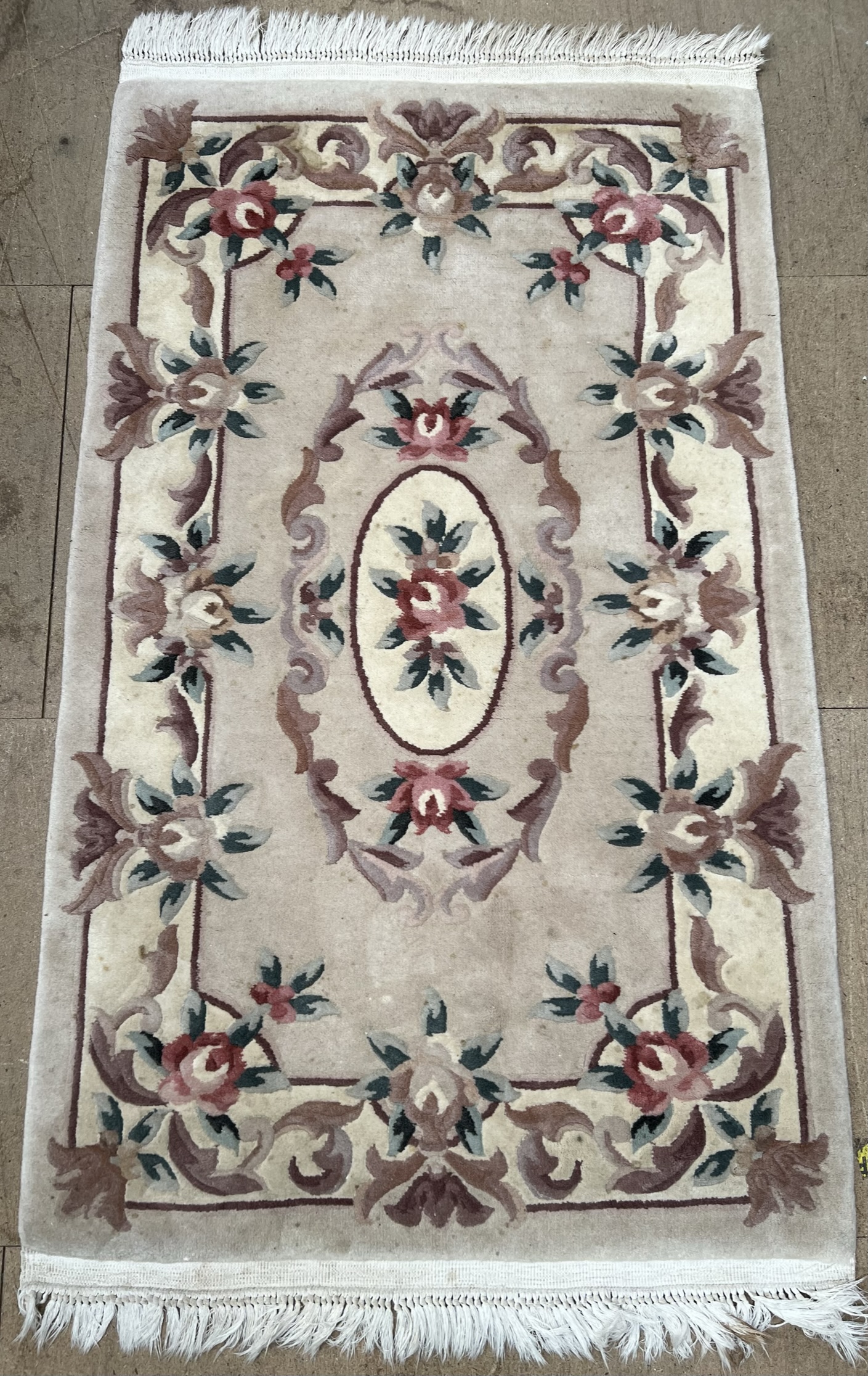 A Chinese cream ground rug with multiple flower heads