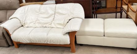 A cream leather three seater settee together with a cream leather ottoman