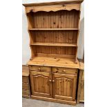 A Modern pine dresser with two shelves above two drawers and a cupboard