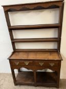 An 18th century South Wales style dresser with a moulded cornice above two shelves,