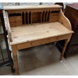 A 20th century pine desk with a raised superstructure with pigeon holes and drawers the base with