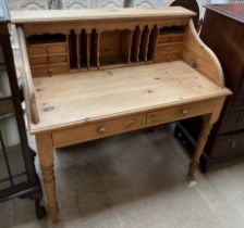 A 20th century pine desk with a raised superstructure with pigeon holes and drawers the base with