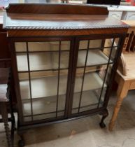 A 20th century mahogany display cabinet with glazed doors and sides on cabriole legs and claw and